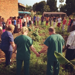 Our team praying over the land where the new church will begin meeting.